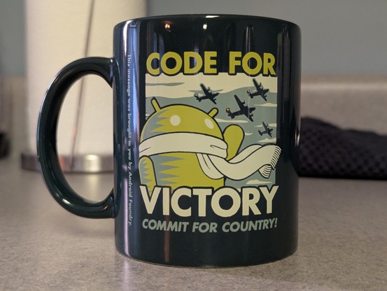 A mug featuring the Android mascot with the text "Code for Victory. Commit for Country!"