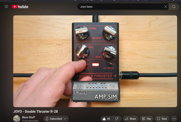 The screencap shows a close-up of a black guitar effects pedal labeled "JOYO - Double Thruster R-28" with the text "AMP SIM" at the bottom. The pedal has four knobs: "TONE," "BLEND," "VOL," and "GAIN," each with a metallic finish and red markings. A hand is pressing the "ON" button, which is illuminated in red. The pedal is connected to a cable, and the background is a light wooden surface. The YouTube interface is visible at the top, with a search bar containing the text "Joyo bass." The video title is "JOYO - Double Thruster R-28," and the channel name is "Bass Stuff," with 13.3K subscribers. The video has 60 likes and options to share, clip, save, and subscribe.

Ovis2-8B

🌱 Energy used: 0.206 Wh