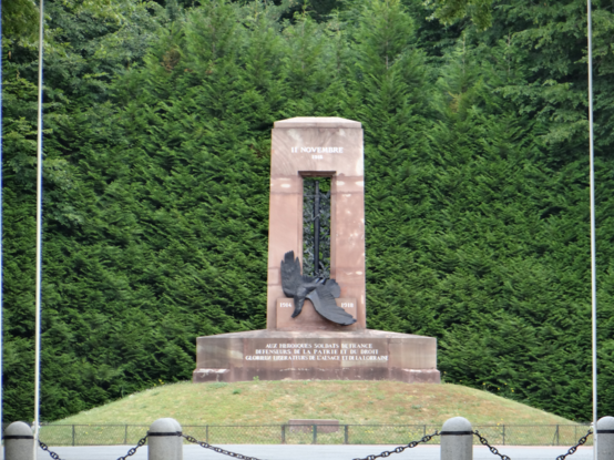 the entire  monument,  standing on a mound, green trees behind it