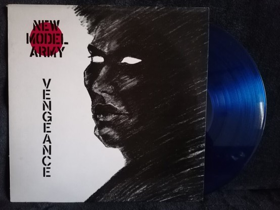 New Model Army - Vengeance, die klar-blaue Schallplatte ist fast zur Hälfte aus dem Cover herausgezogen.