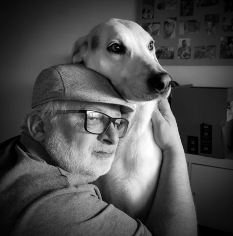 Ich umarme einen weißen Hund. Das Foto ist in Schwarzweiß.