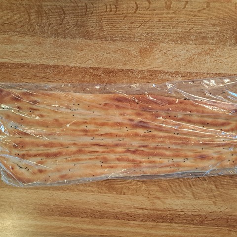 Large flat bread in plastic on a counter