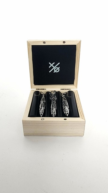 A matched set of intricate solid .925 silver latticework earrings and pendant necklace. The pieces are nestled in a custom wood box presented on a white background.