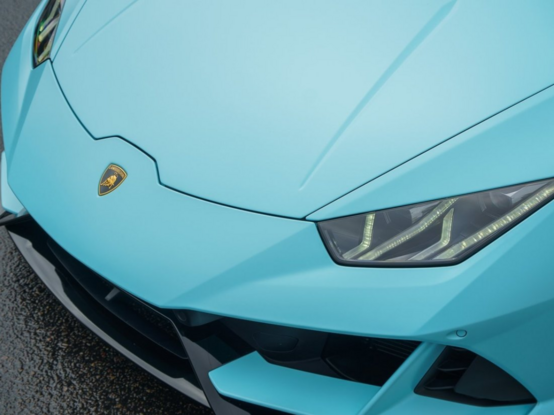 a close-up looking down at the hood , the car is powder blue
