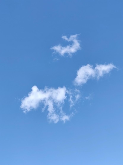 A narrow cloud shape, the larger below the smaller, against a blue sky.