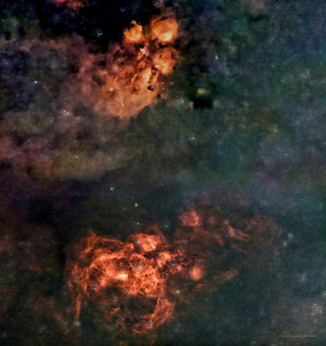 A blue-green cloudiness or faint nebula, with two bright red-orange nebulae, one above the other. The top resembles the pawprint of a cat, while the lower looks like a scorpion or lobster.