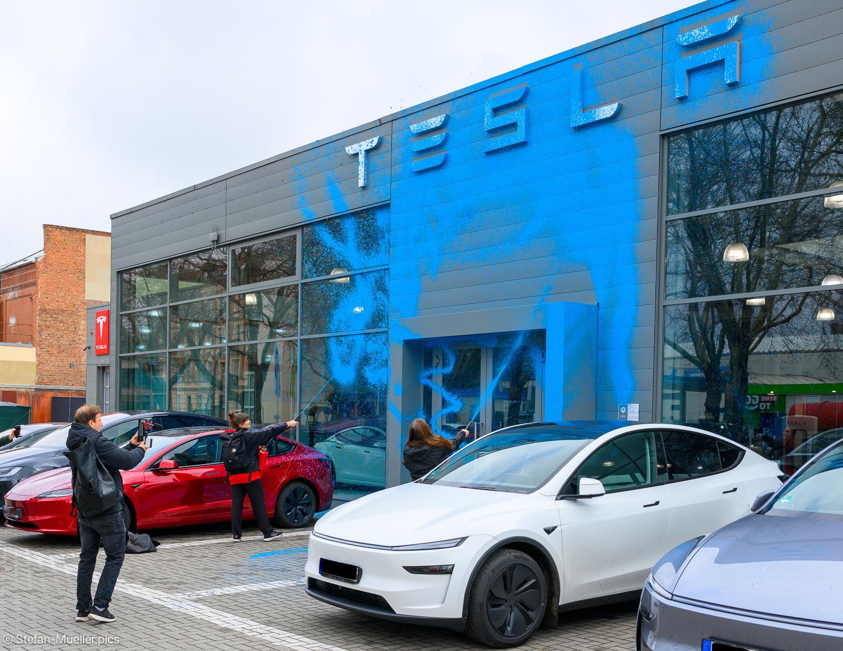 Emma Dorrow und Judith Beadle von der Neuen Generation besprühen TESLA-Store mit AfD-blauer Farbe. Tesla-Center in Berlin Reinickendorf, 31.03.2025