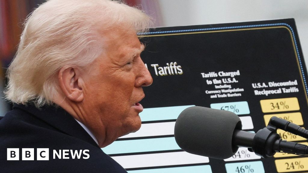 Donald Trump is outside and seen in a close profile shot wearing a dark coat with the country tariffs list behind him and a microphone next to his face.