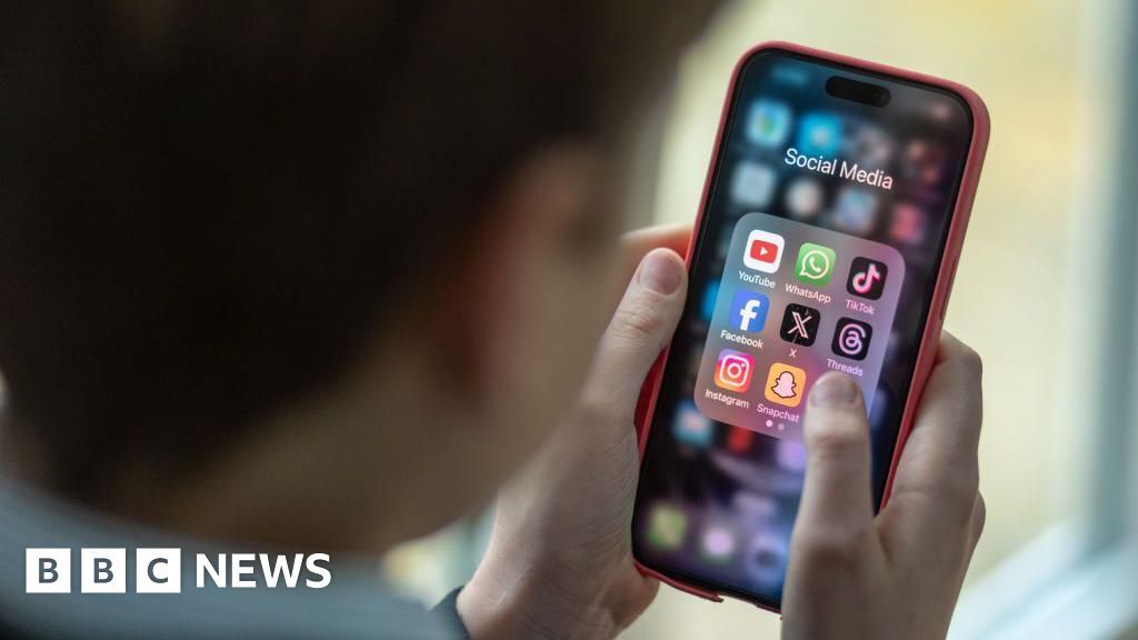 A 12-year-old boy looks at an iPhone screen showing various social media apps including TikTok, Facebook and X on 25 February 2024.