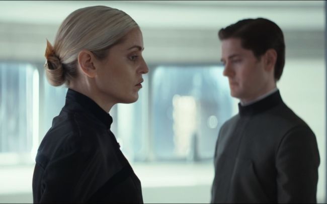 Denise Gough and Kyle Soller in 'Andor' Season 2, standing next to each other but not looking at each other in a very white apartment.