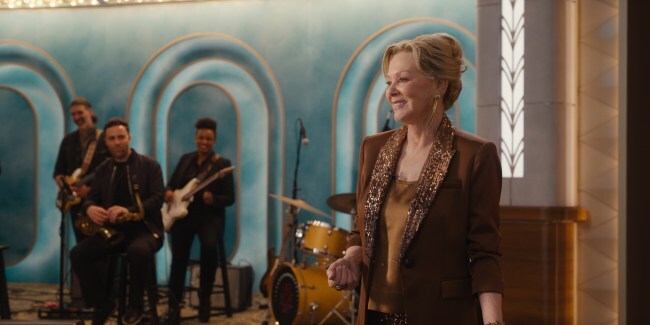 Jean Smart as Deborah Vance standing on the set of her late night show with a band behind her in 'Hacks'
