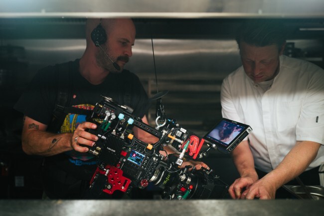 Camera operator Joel Marsh shooting chef Jamie Oliver plating a dish in his kitchen in London.