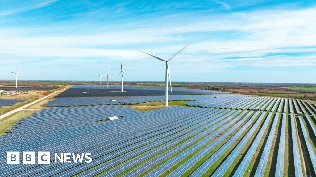 Solar panels and wind turbines shown in a landscape