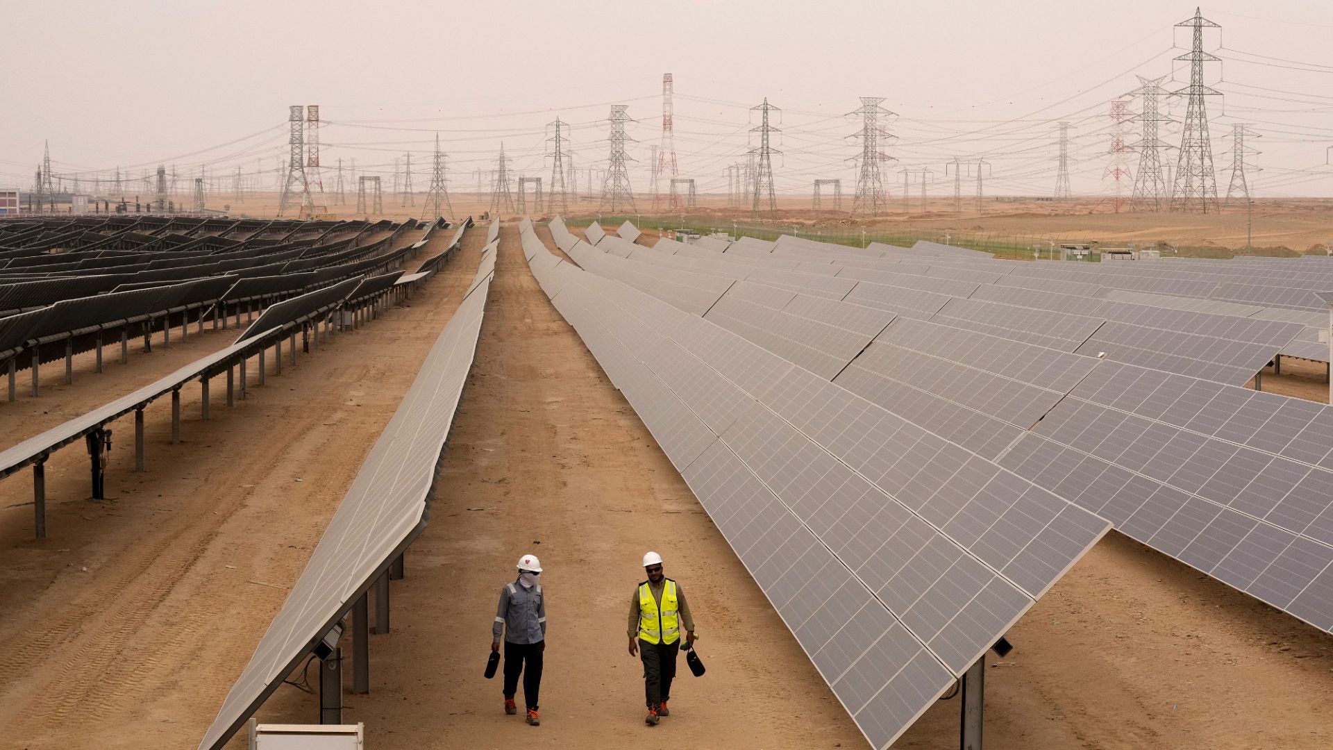 Engineers walk next to solar panels at Benban Solar Park in Aswan. | Copyright AP Photo
