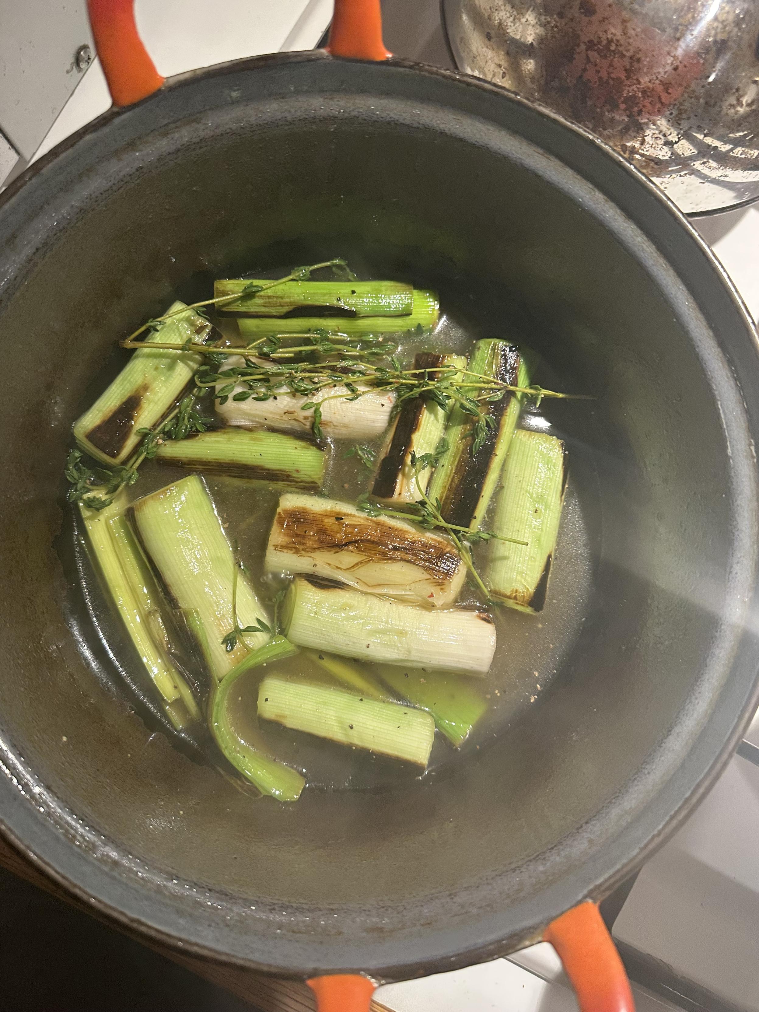 Slightly charred (ahem... "caramelised") pieces of leek in a cast-iron pan with thyme and apple juice.
