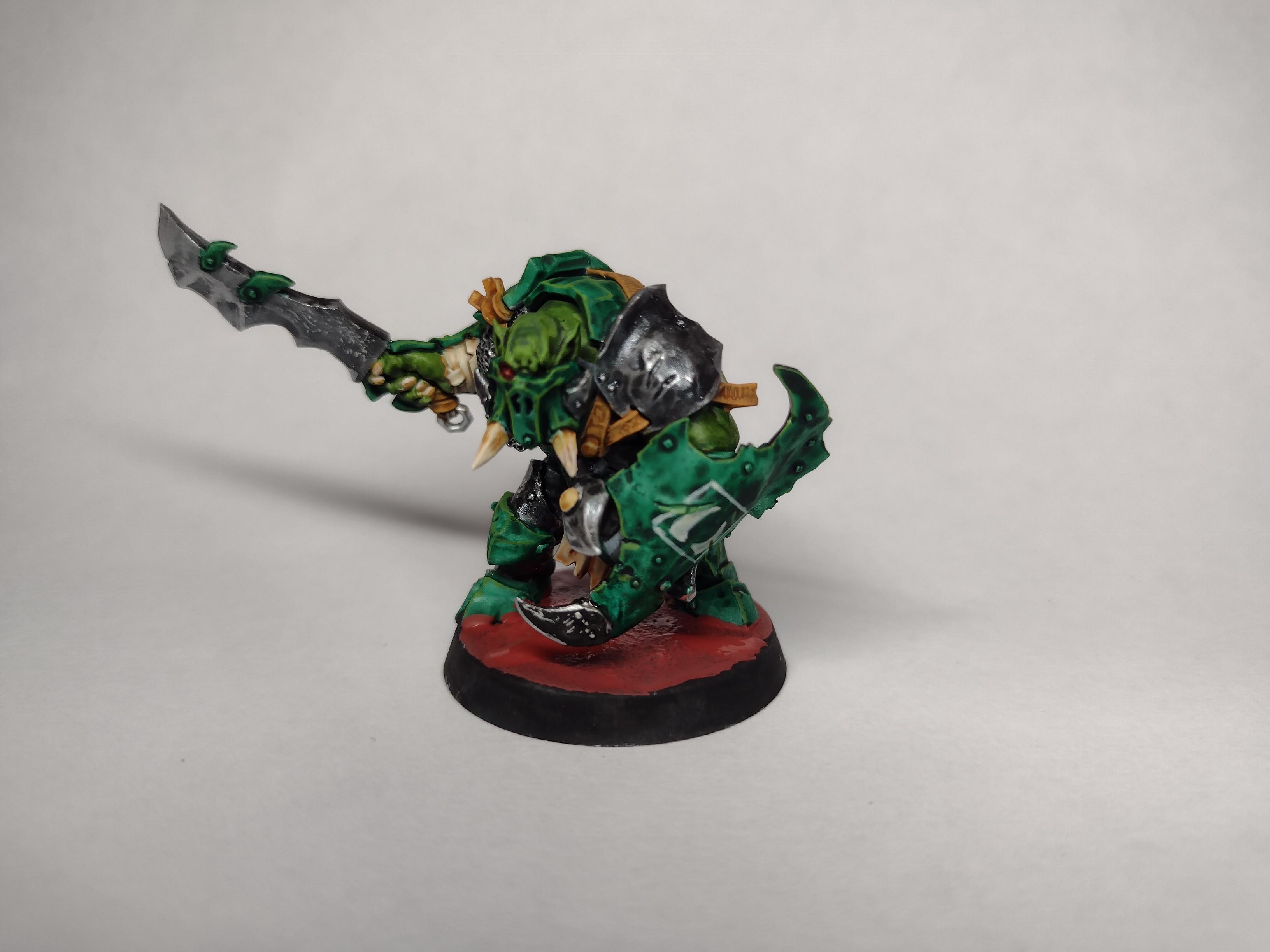 Painted miniature of an orc with a heavy green armour.