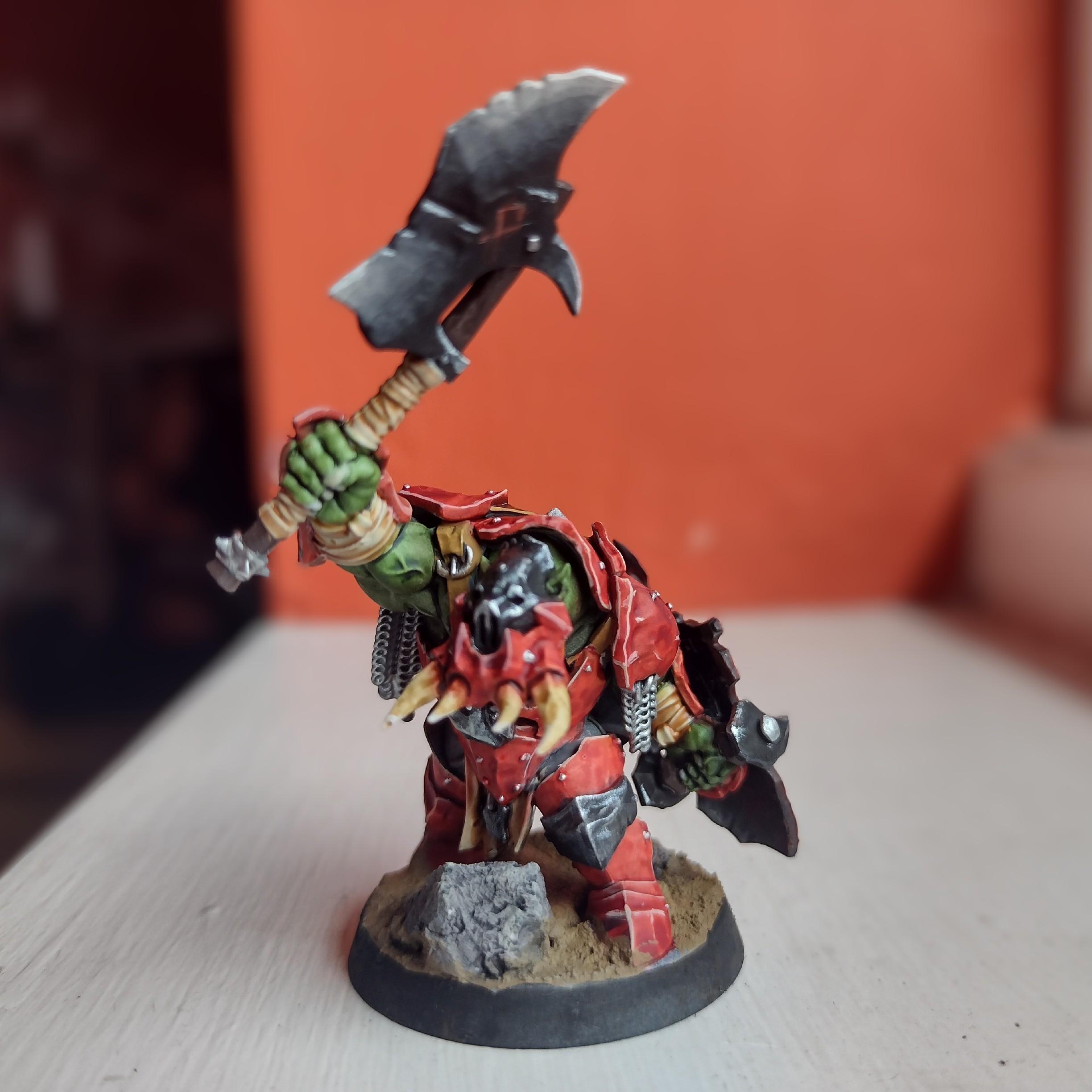 Miniature of an orc with a heavy armour (painted red) and a big chopper