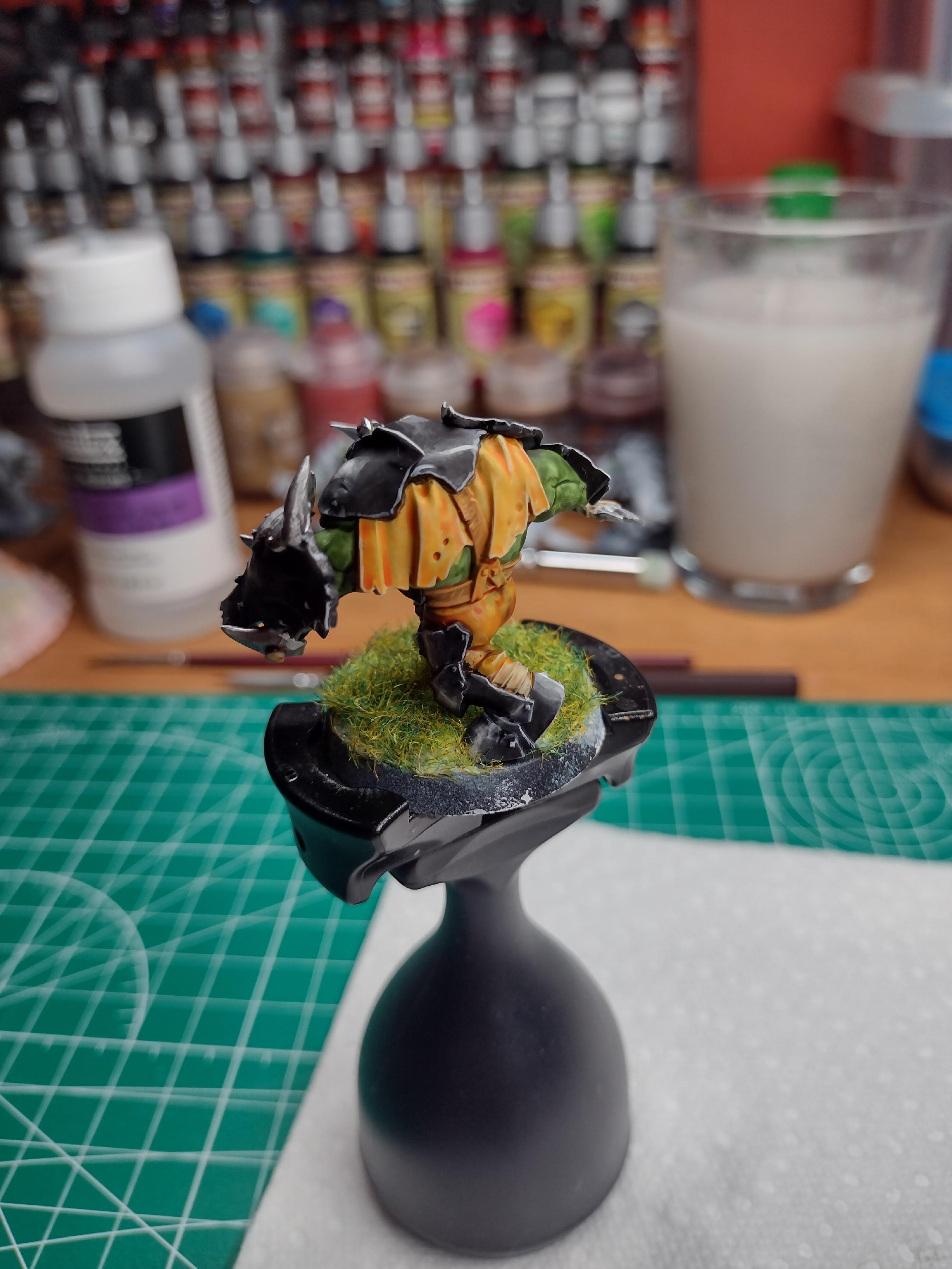 Orc miniature painted with a black armour.
This picture is taken from behind, showing the yellow/brown clothes.