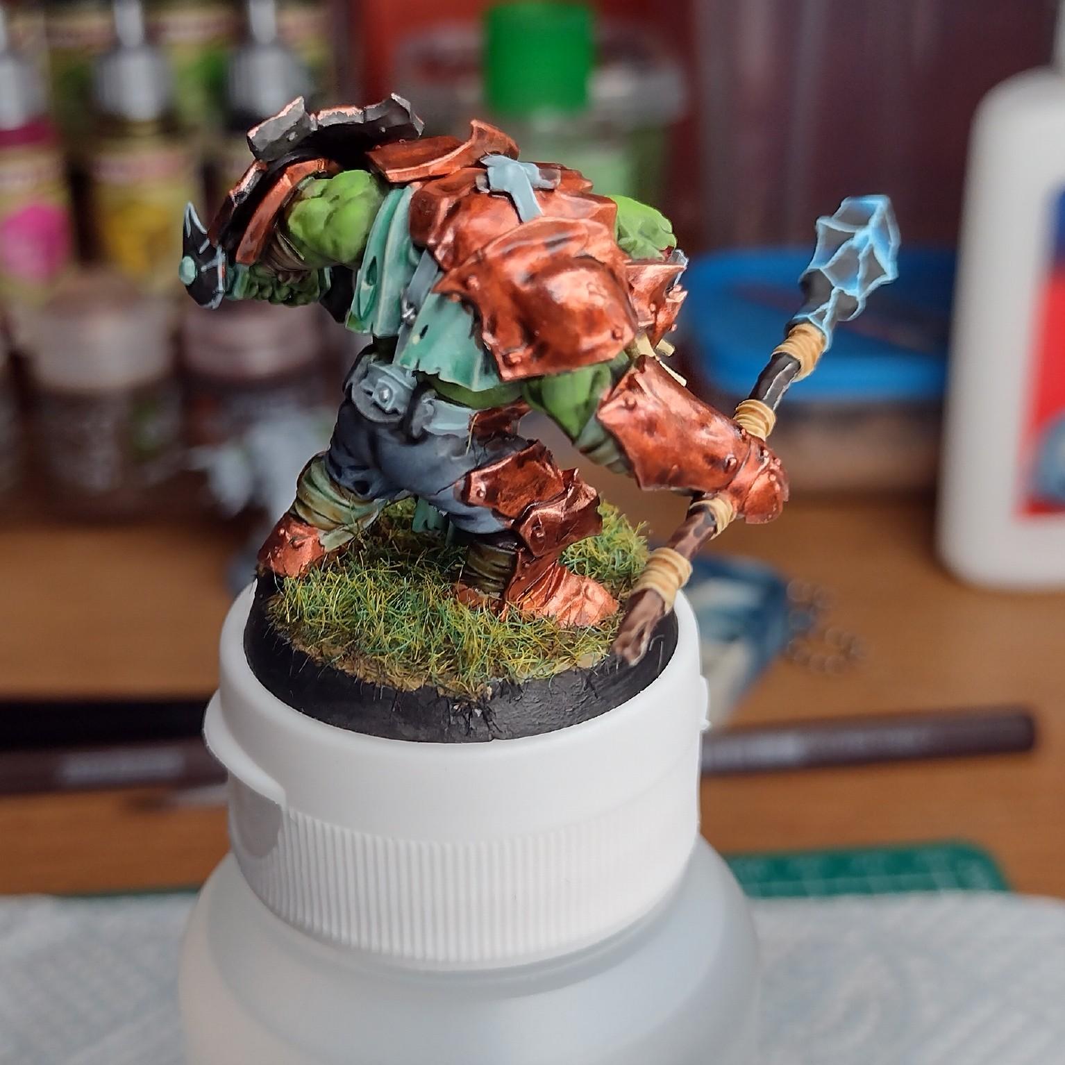 Orc miniature painted with a copper armor.