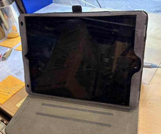 an iPad on a desk, using its cover as a stand. 