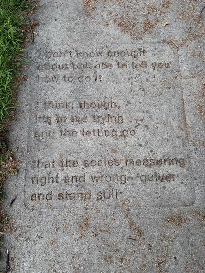 A sidewalk with a poem imprinted in it:

I don't know enough
about balance to tell you
how to do it

I think, though,
it's in the trying 
and the letting go

that the scales measuring 
right and wrong -- quiver
and stand still