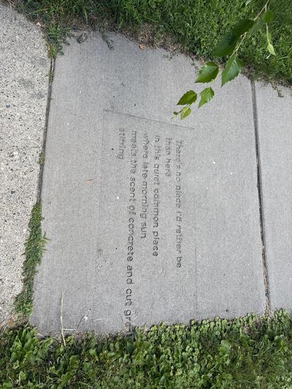 A sidewalk with a poem imprinted in it:

there's no place I'd rather be
then here
in this quiet common place
where late morning sun
meets the scent of concrete and cut grass
stirring