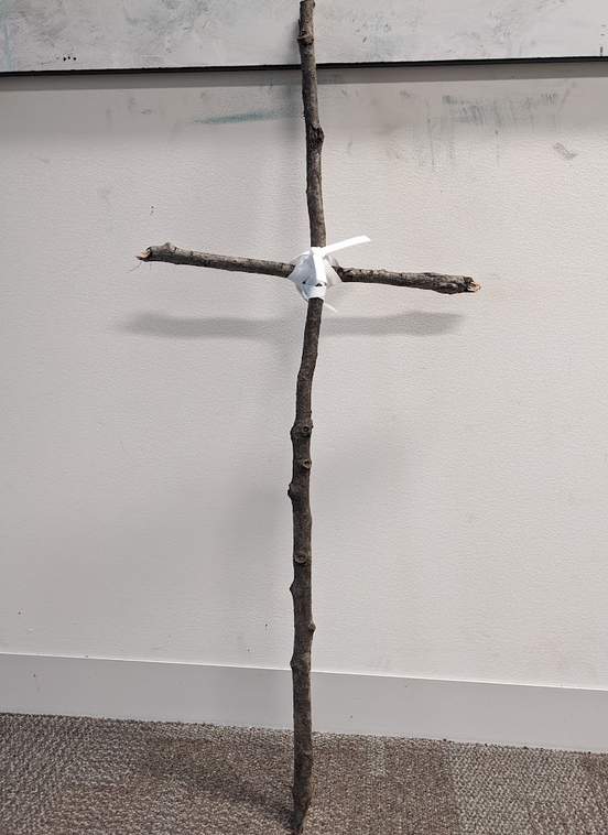 A cross made of two sticks, intended as a crude representation of a human figure