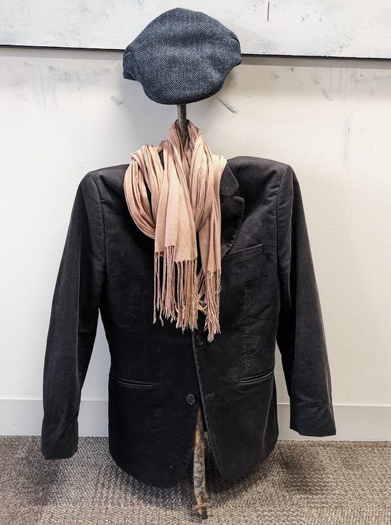 The same cross wearing a jacket, scarf, and hat, looking much more like a human!